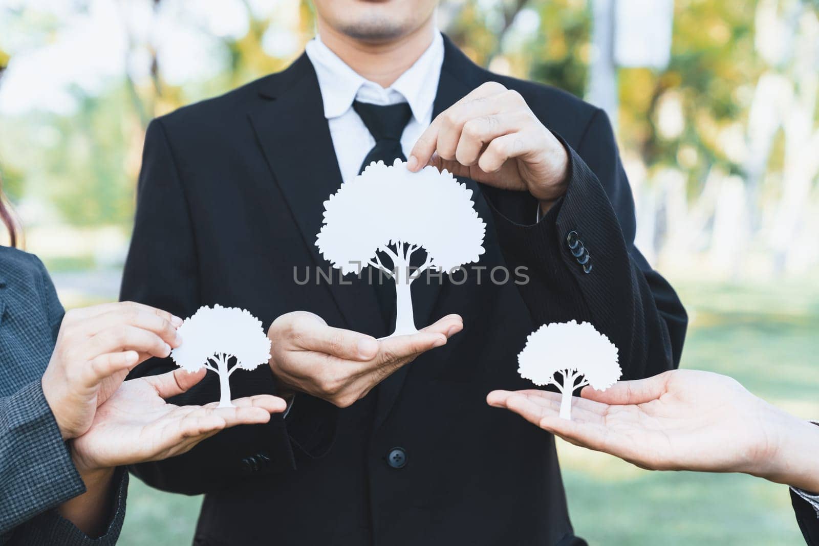 Group of business people holding white paper tree showcase environmental protection nurturing with nature, reduce CO2 and green house gases emission with reforestation for greener future. Gyre