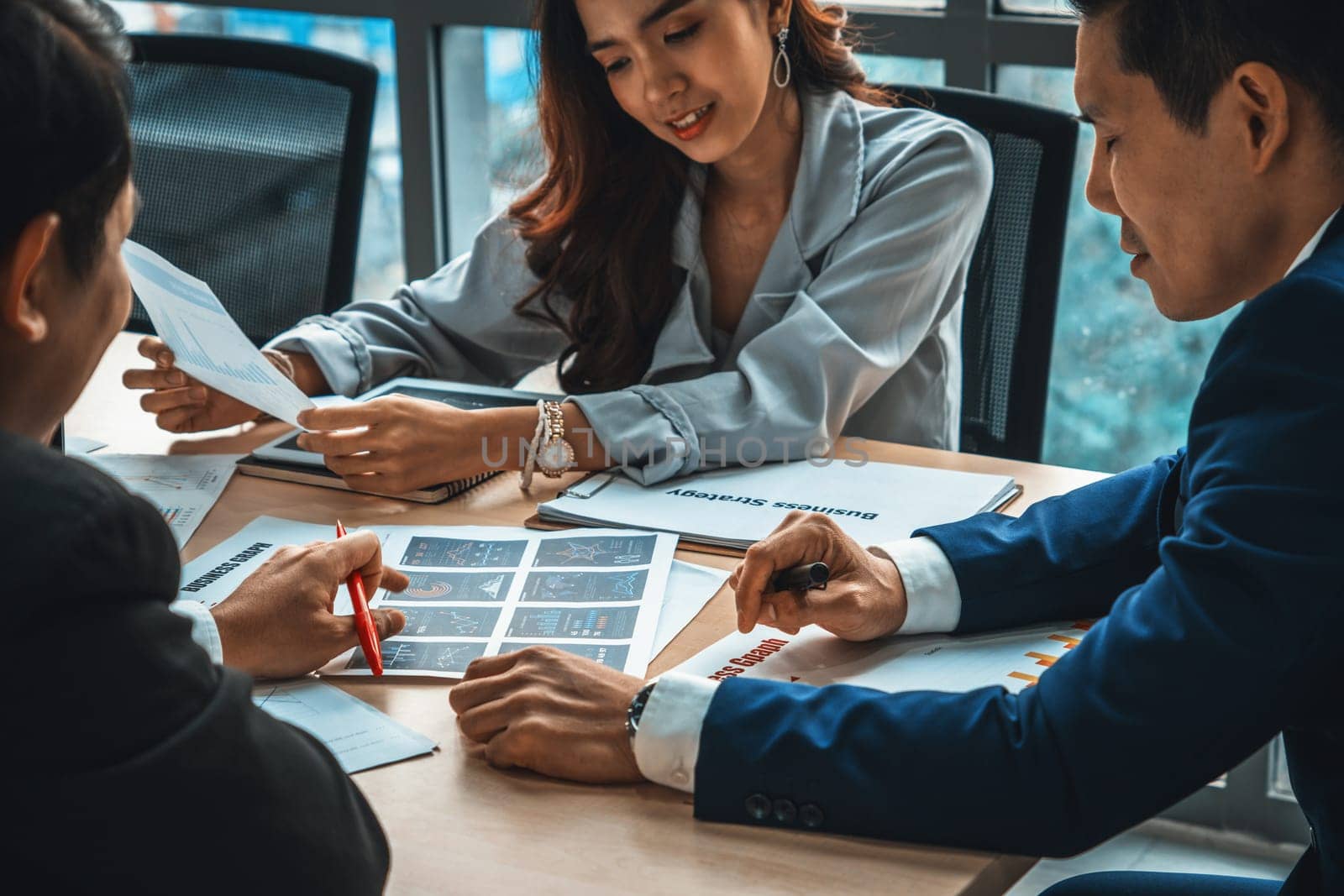 Smart businessman and businesswoman talking discussion in group meeting at office table in a modern office interior. Business collaboration strategic planning and brainstorming of coworkers. Jivy