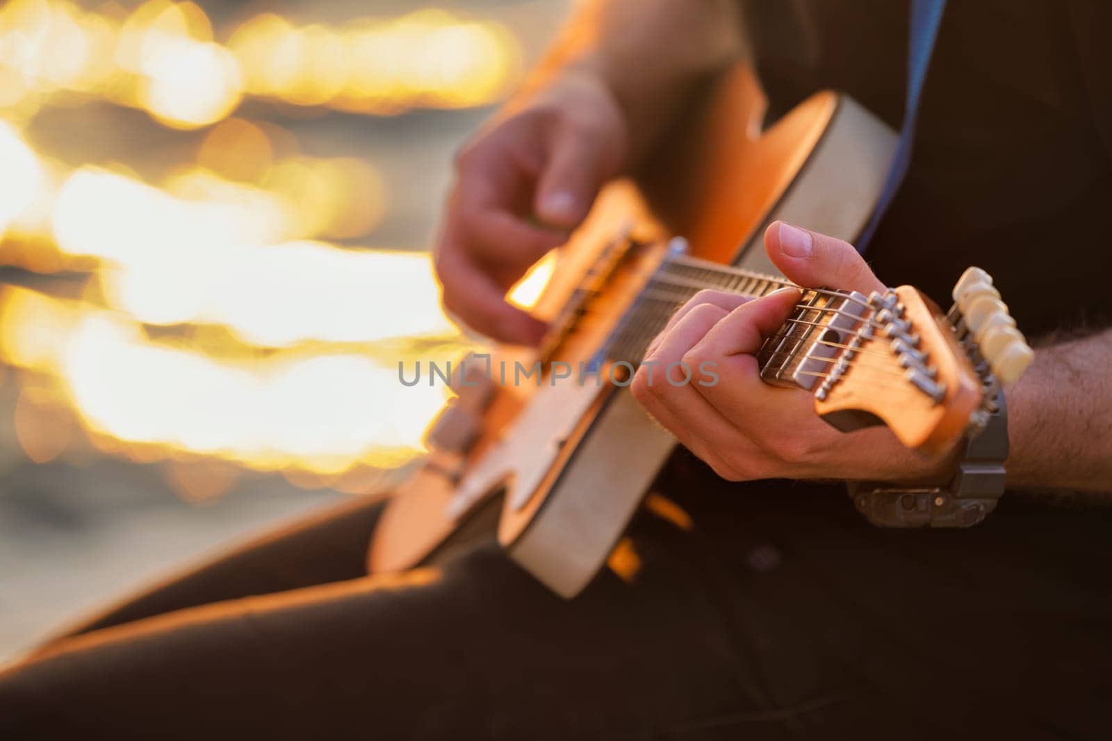 Street musician playing electric guitar hands close up by dimol