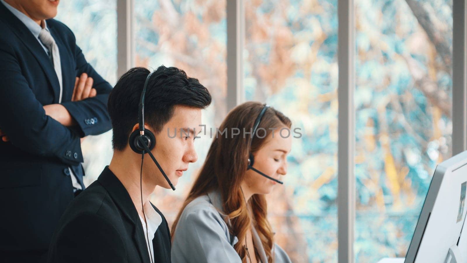 Business people wearing headset working in office to support remote customer or colleague. Call center, telemarketing, customer support agent provide service on telephone video conference call. Jivy