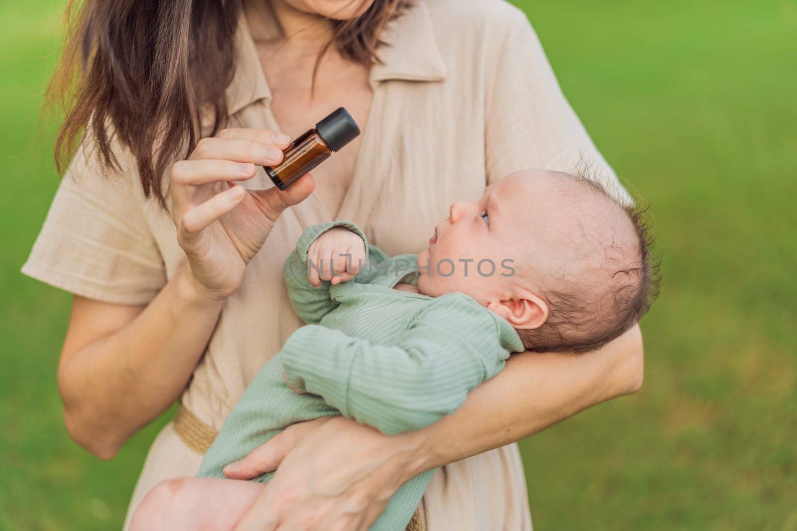 Loving mother gently applies soothing aroma oils to her precious newborn, creating a calming and nurturing atmosphere by galitskaya