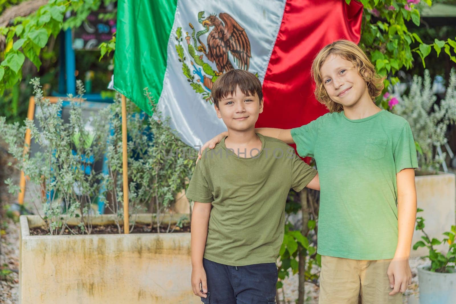 Immigrant boys in Mexico in front of the Mexican flag. New Mexicans.