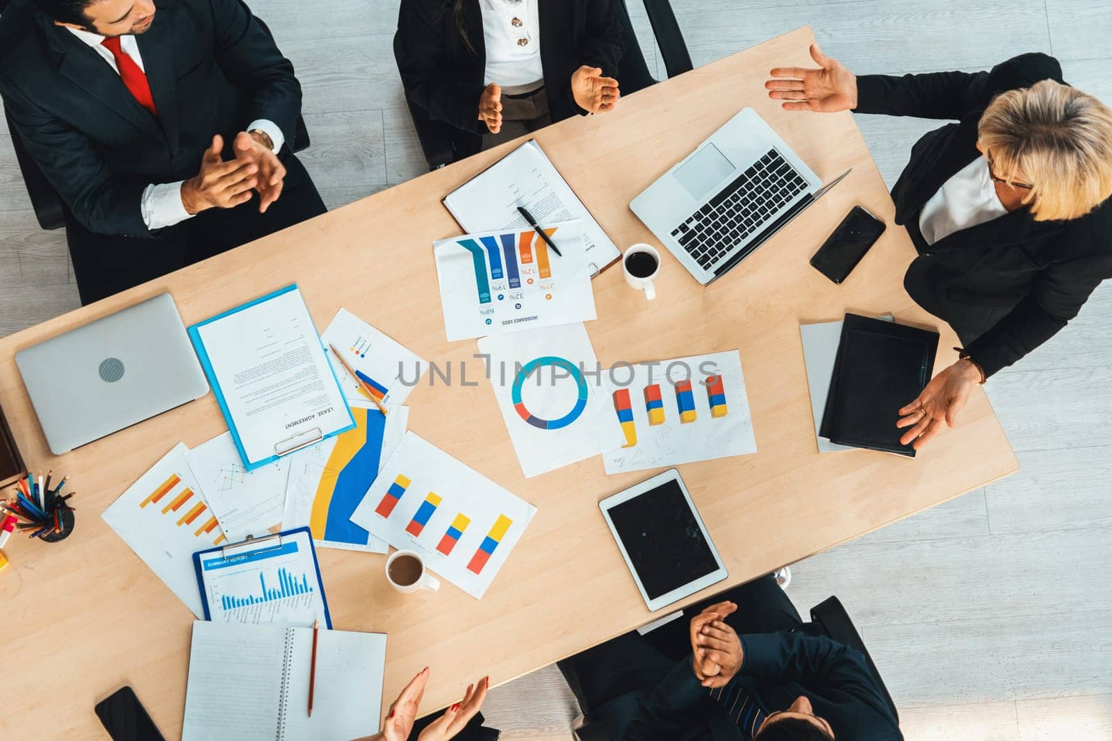 Business people group meeting shot from top view in office . Profession businesswomen, businessmen and office workers working in team conference with project planning document on meeting table . Jivy