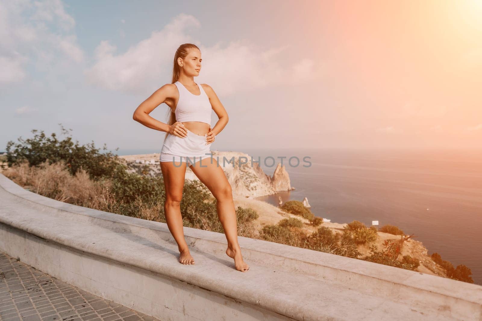 Fitness woman sea. Outdoor workout on yoga mat in park near to ocean beach. Female fitness pilates yoga routine concept. Healthy lifestyle. Happy fit woman exercising with rubber band in park.