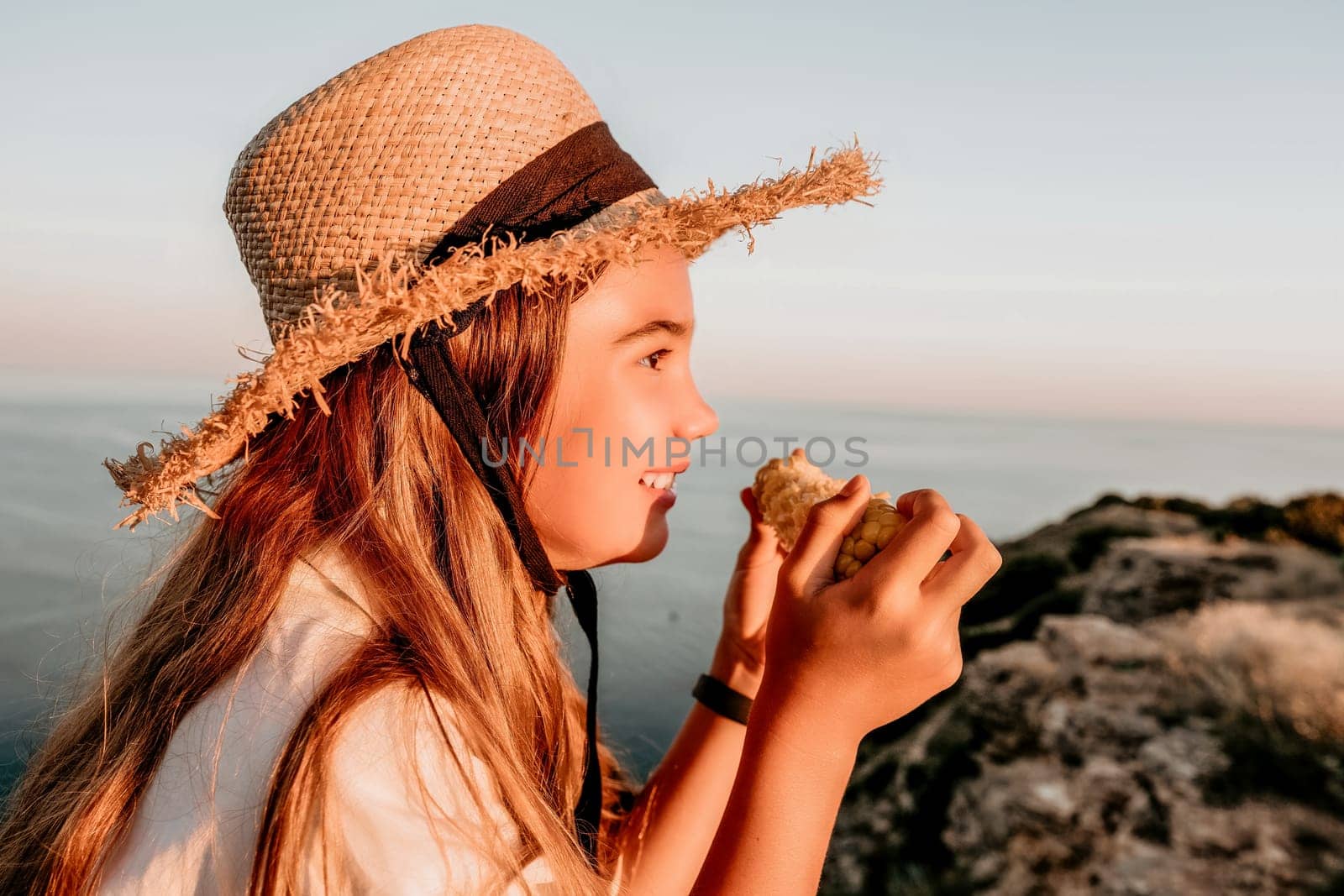 Portrait of young beautiful girl eating corn. Snacking on the sea