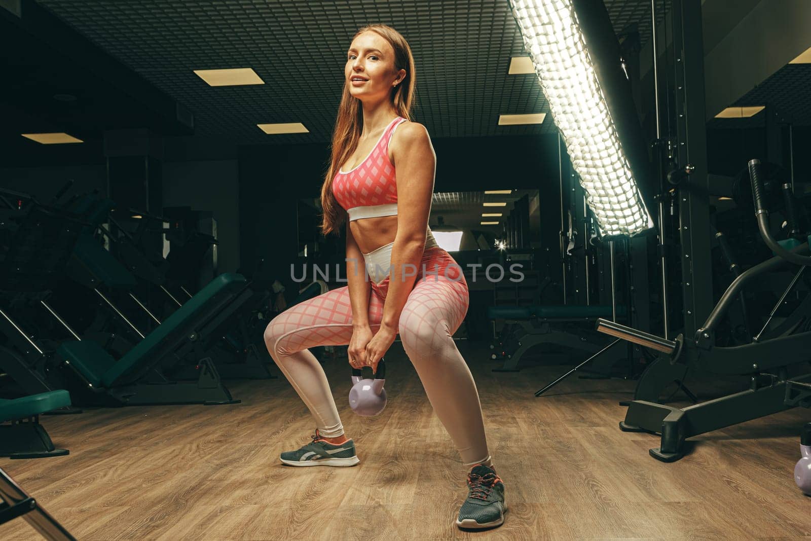 Pretty fit woman doing exercises in a gym