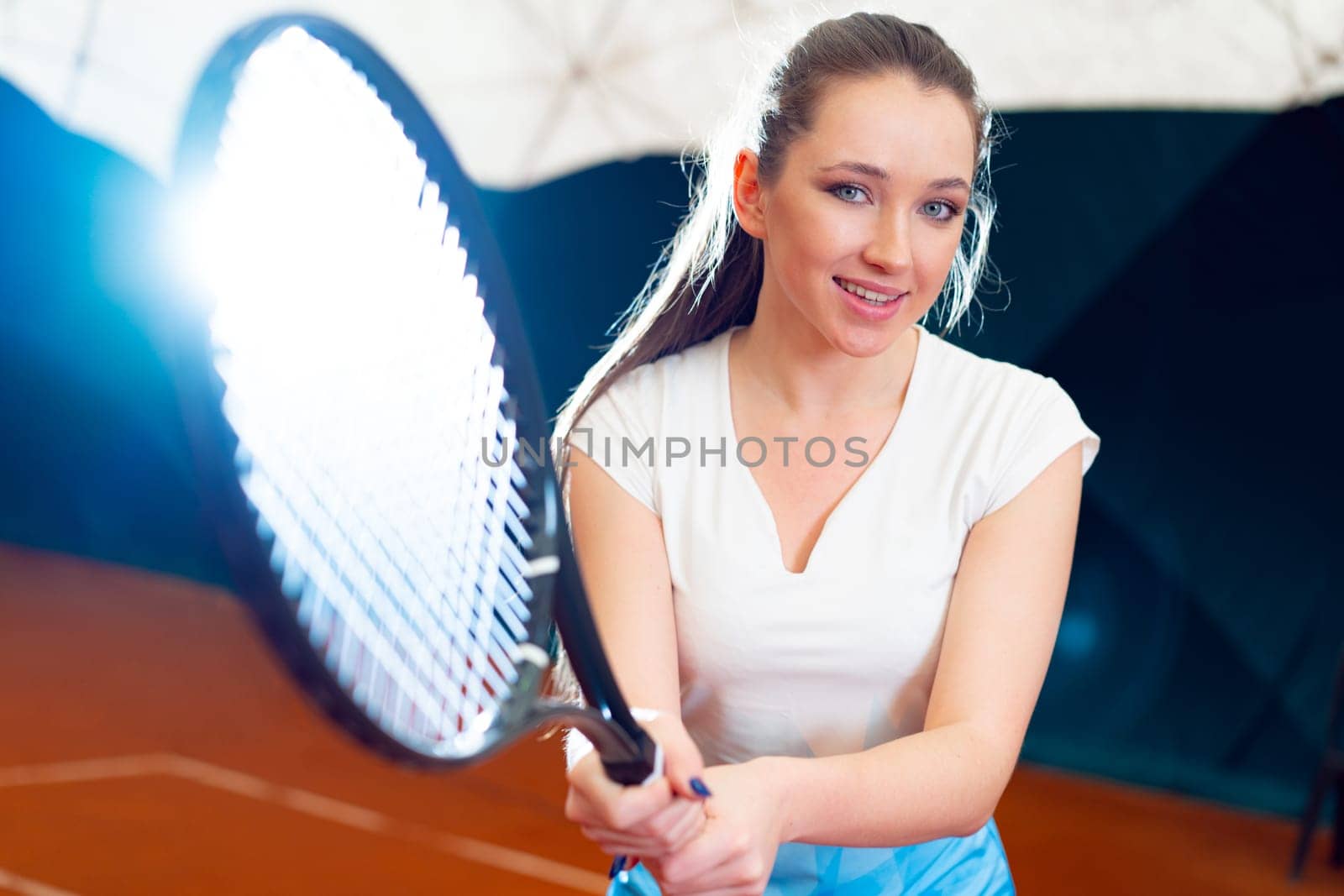 Close up portrait of a young attractive woman tennis player holding tennis racket