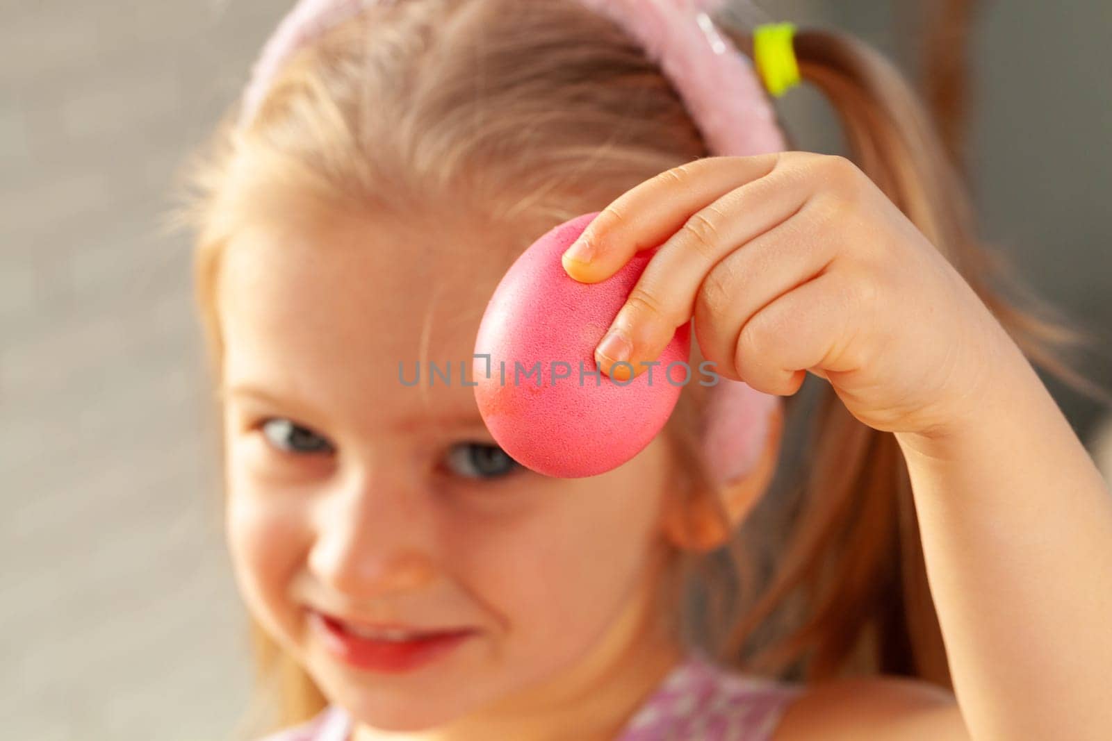 Happy little girl just painted an egg for Easter