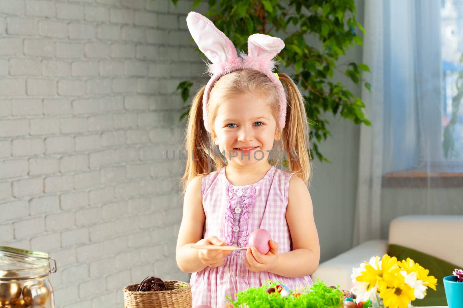 Little girl painting eggs for Easter at home