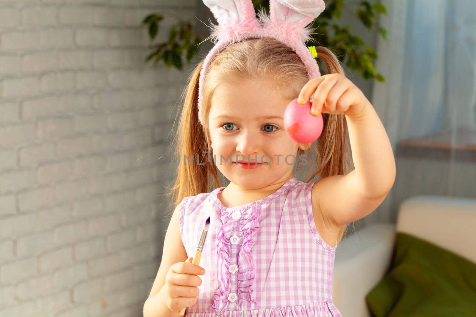 Happy little girl just painted an egg for Easter