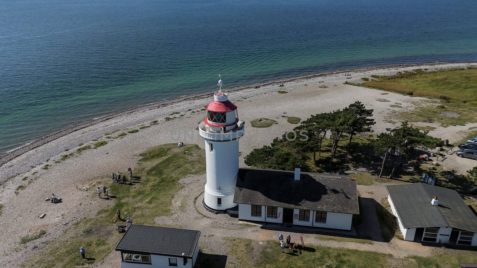 Djursland,Denmark,31-08-2024: people anjoy the summer at the white round lighthouse Sletterhage on the Helganaes peninsula ,drone photo