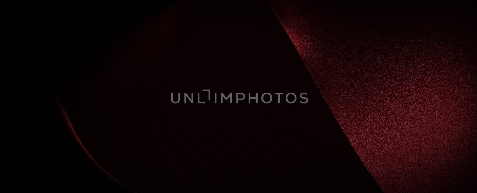 A close-up of a red fabric, the light subtly highlights its texture and creates an abstract, almost artistic, composition.