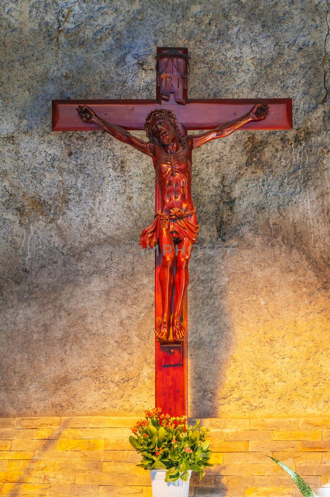 Wooden cross crucifixion with Jesus Christ God in a Catholic church