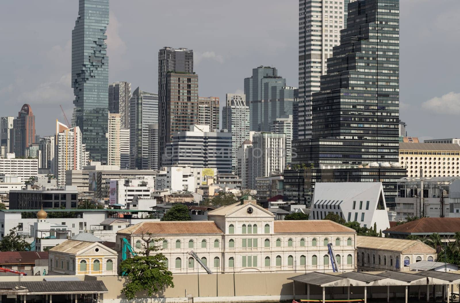 Bangkok, Thailand - 28 Sep, 2024 - Exterior view of The old customs house Or Old bang rak fire station building with Skyscrapers background at Bangkok city. Architectural View of Old and New Buildings in Contrasting Classical and Modern Designs, Space for text, Selective focus.