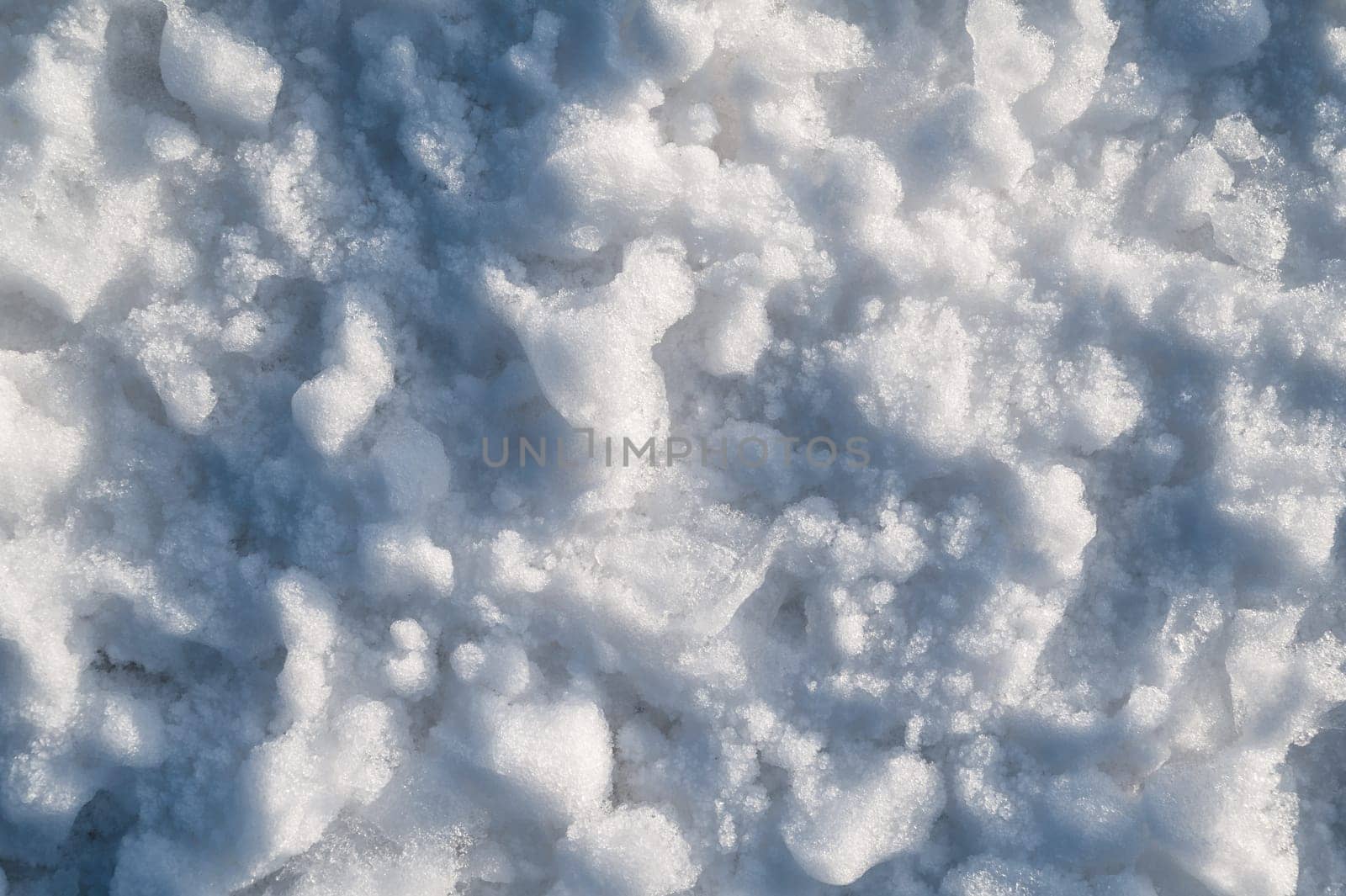 Background with texture of white snow on a snowdrift on a cold winter day
