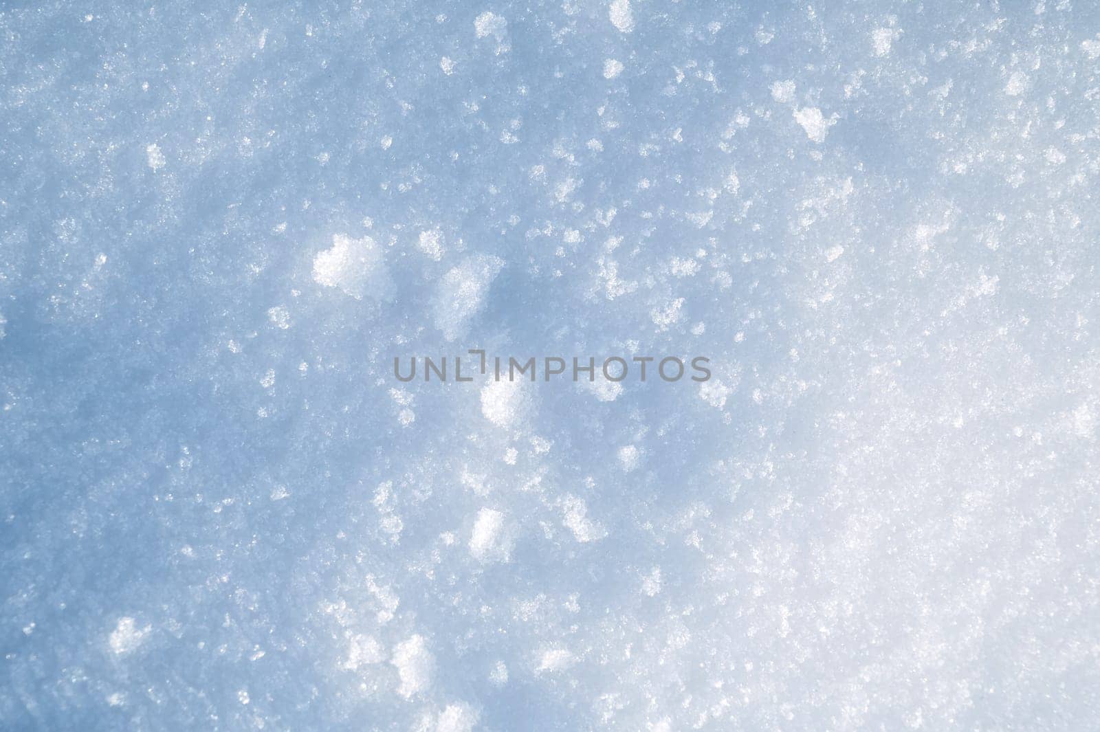 background with a texture of white blue snow on a snowdrift on a cold sunny winter day