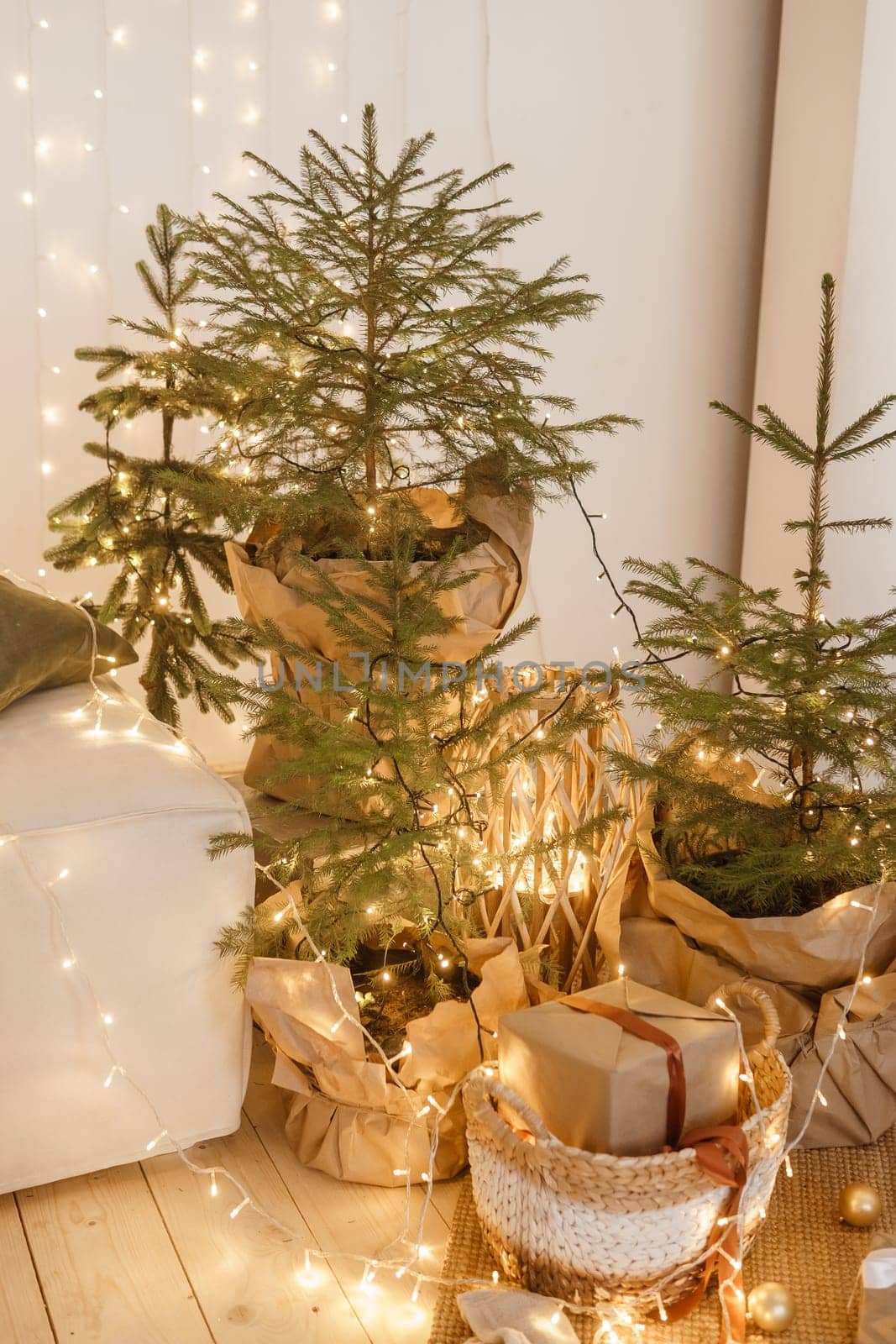 Designer Christmas tree decoration with light decorations. The concept of celebrating New Year and Christmas. Gifts in craft packaging under the Christmas tree.