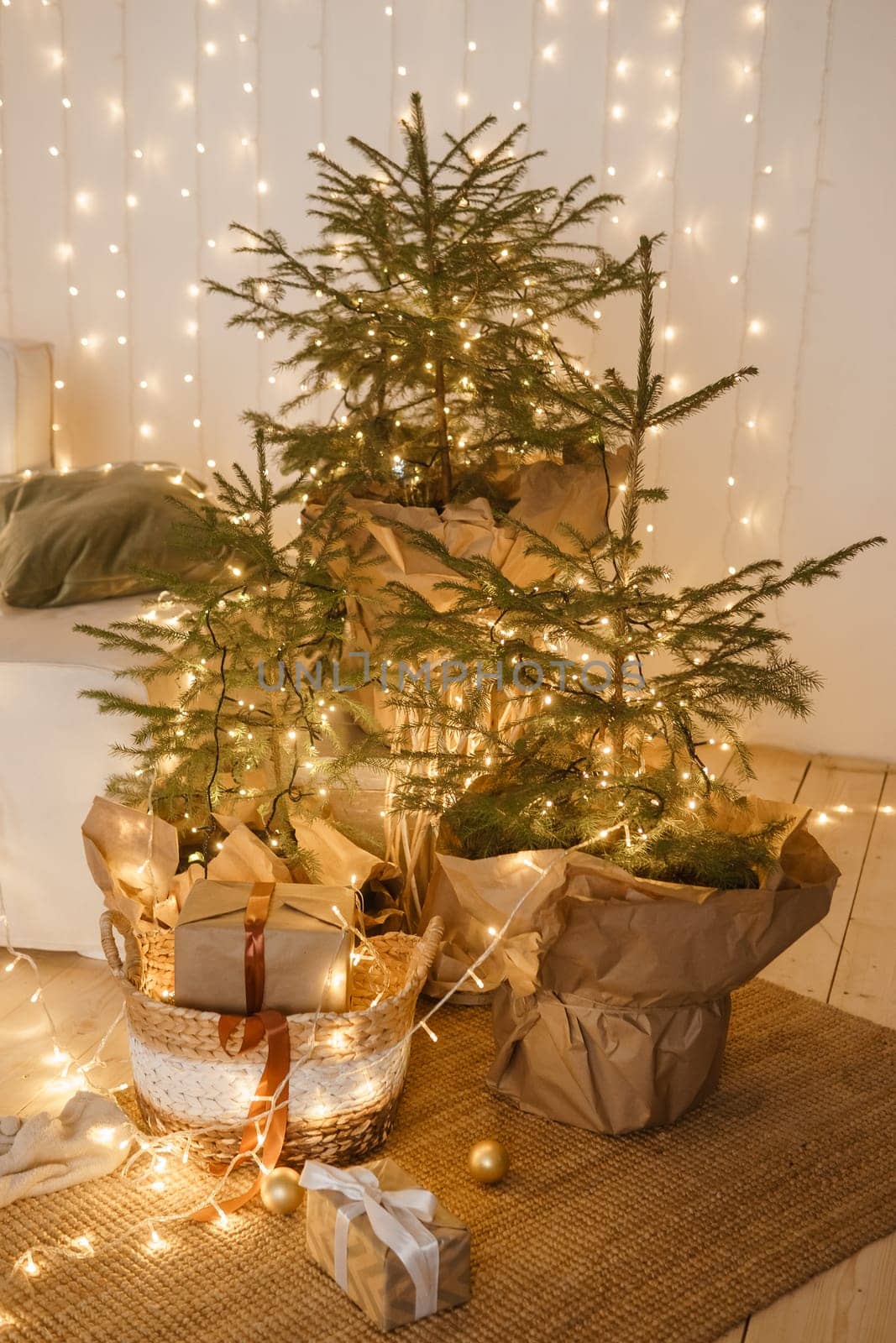 Designer Christmas tree decoration with light decorations. The concept of celebrating New Year and Christmas. Gifts in craft packaging under the Christmas tree.