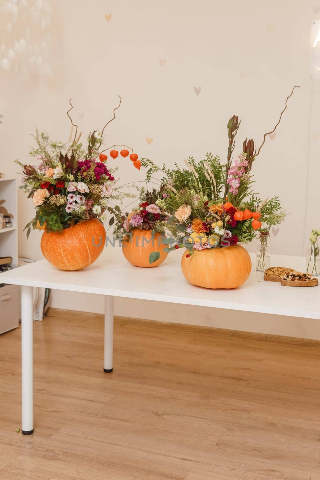 Flower arrangement in a pumpkin, autumn interior decor. Creating handmade autumn decor