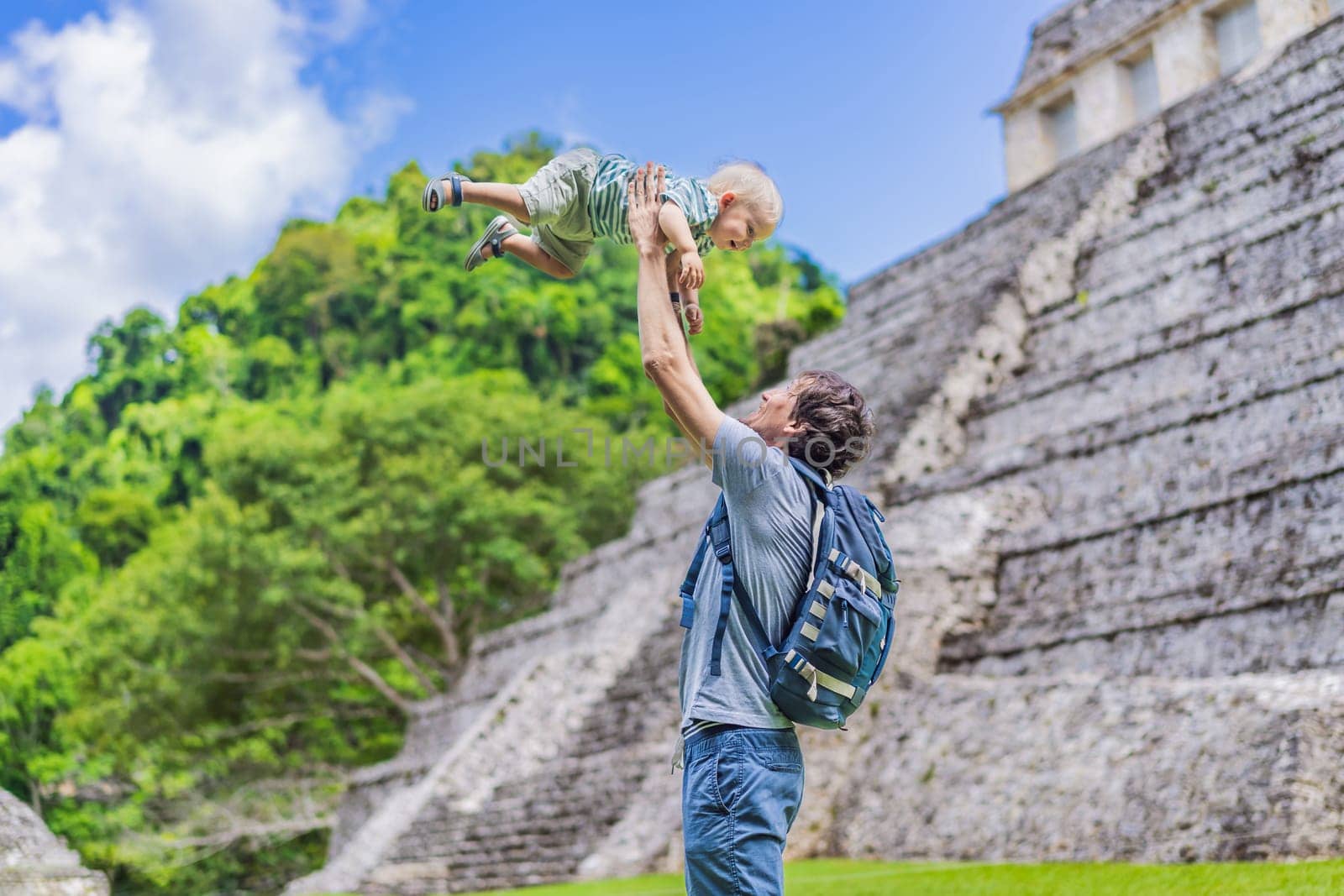 Mother with his toddler son exploring the ancient pyramids of Palenque, Mexico, surrounded by dense jungle. Cultural heritage and adventure travel concept.