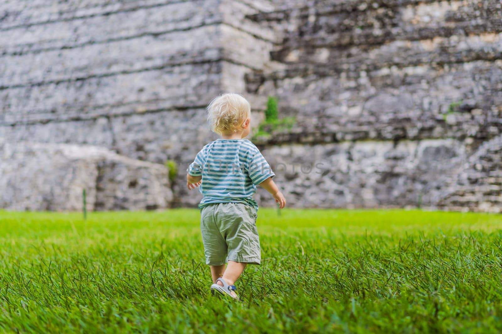 Baby tourist exploring the ancient pyramids of Palenque, Mexico, surrounded by dense jungle. Cultural heritage and adventure travel concept.
