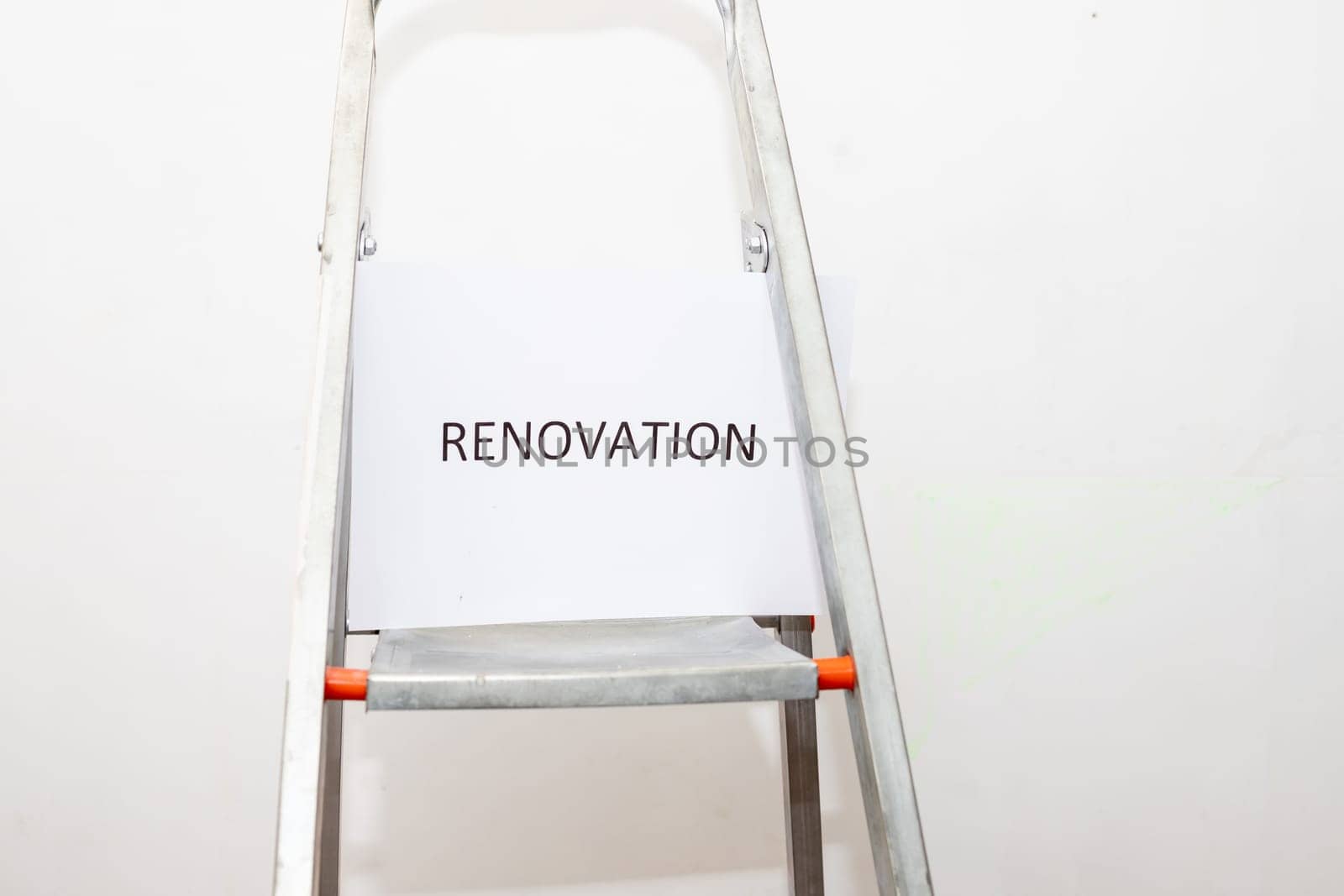 Stepladder and painting tools near wall in empty room