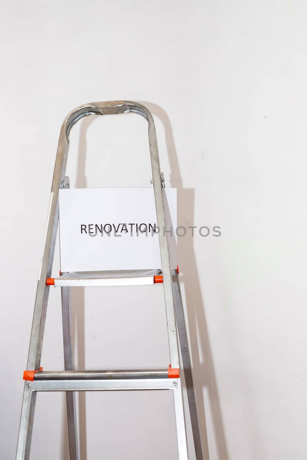 Stepladder and painting tools near wall in empty room