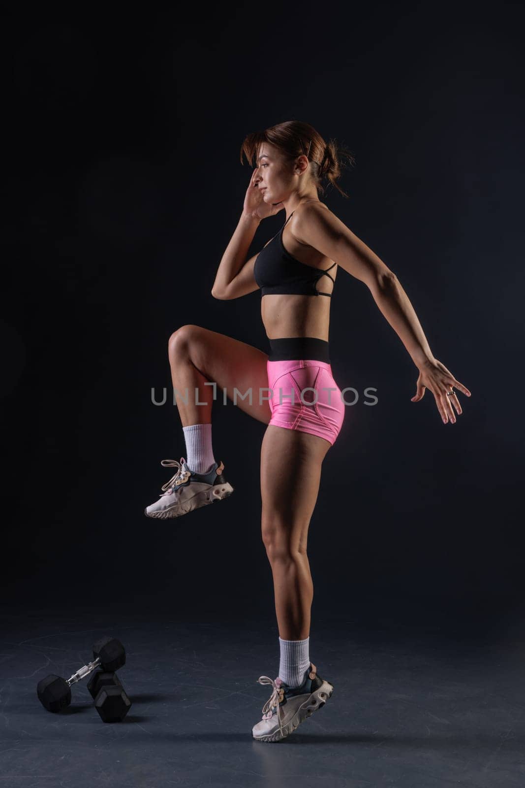 sporty girl doing exercises with dumbbells on black background, sport concept, healthy and beautiful body