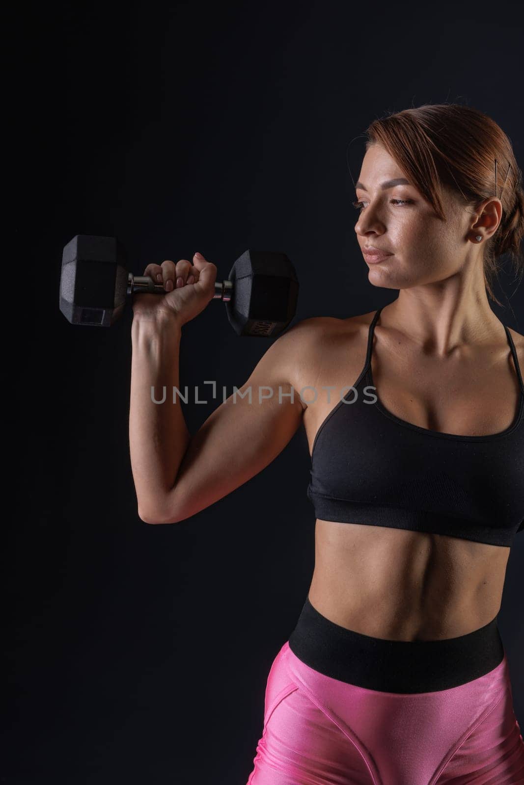 sporty girl doing exercises with dumbbells on black background, sport concept, healthy and beautiful body