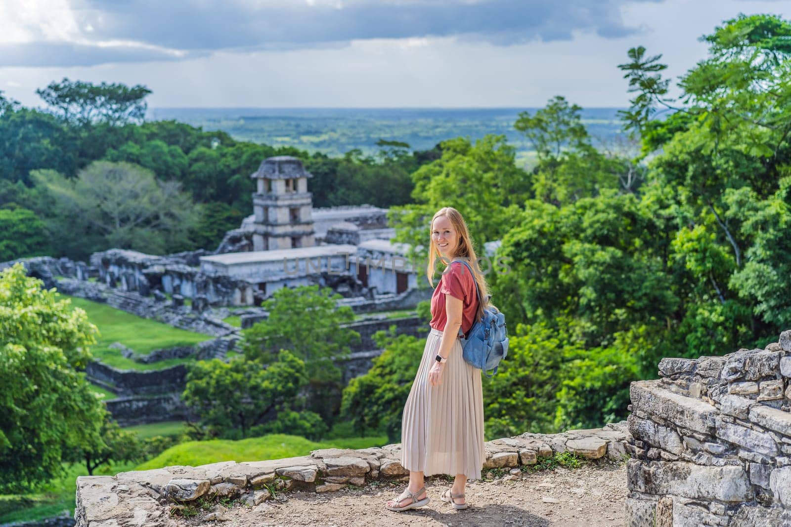 Female tourist exploring the ancient pyramids of Palenque, Mexico, surrounded by dense jungle. Cultural heritage and adventure travel concept.