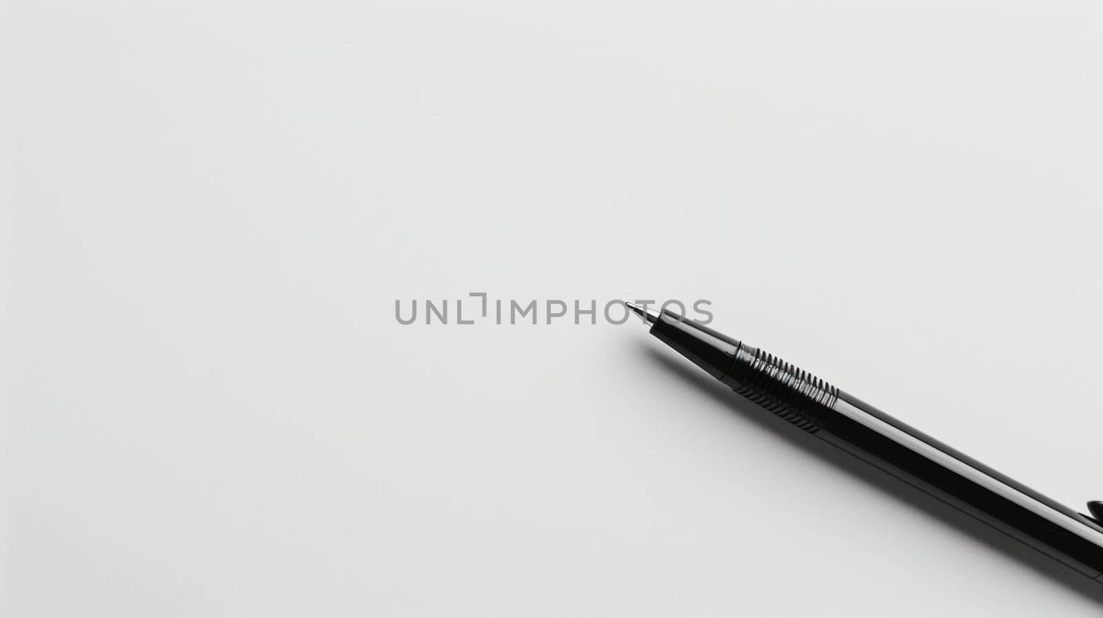 A sleek black ink pen is positioned diagonally across a pristine white background, showcasing its refined design. The pen's smooth surface reflects light, highlighting its shape and details. This arrangement emphasizes the minimalist aesthetic of office supplies.