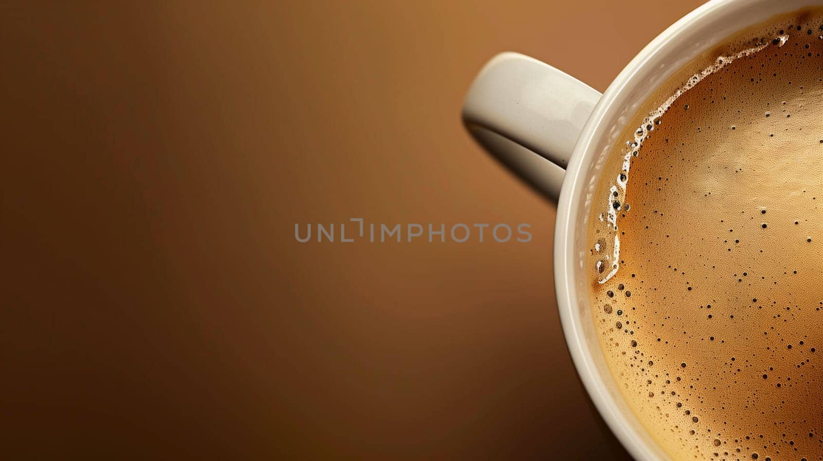A warm cup of coffee sits atop a wooden table, showcasing rich, foamy cream on its surface. The setting exudes a cozy atmosphere, illuminated softly by natural light streaming in through a nearby window. The deep brown hues of both the coffee and the table create a warm and inviting feel.