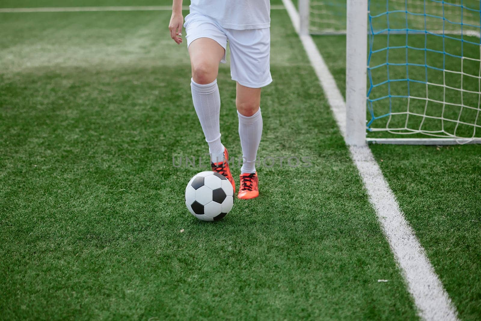 And the soccer player in the uniform and red clothes controlling the soccer ball on the Green Field. football training