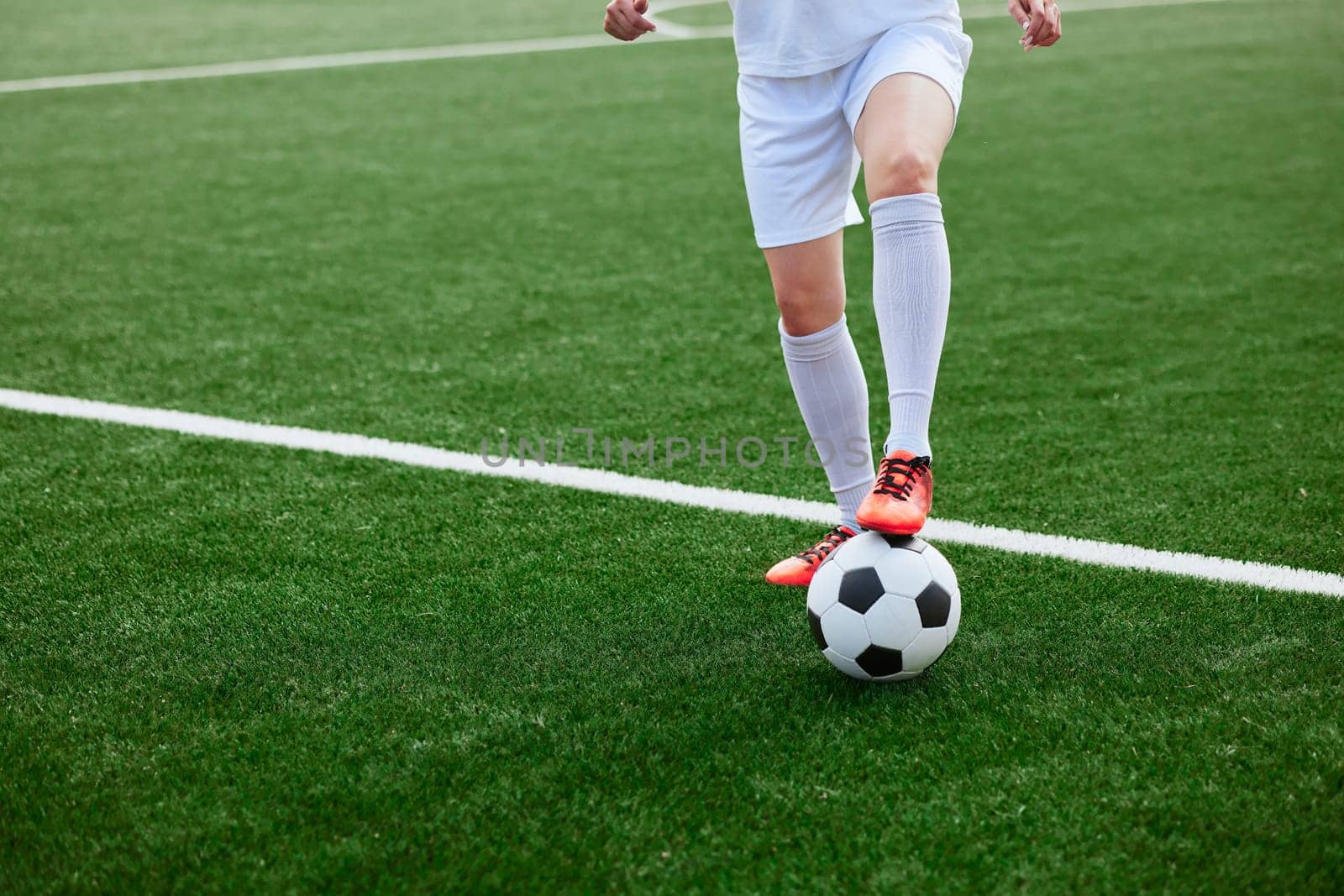 And the soccer player in the uniform and red clothes controlling the soccer ball on the Green Field. football training