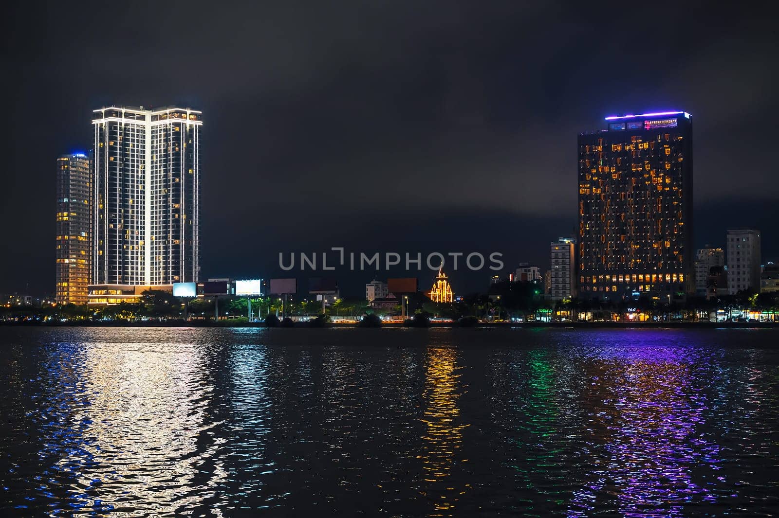 Night panorama of Da Nang city with the Han River embankment and hotels skyscrapers on the shore at night in Vietnam