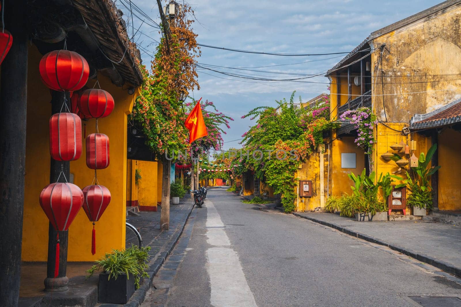 Streets with traditional ancient yellow houses in the old town in Hoi An city in Vietnam at summer day