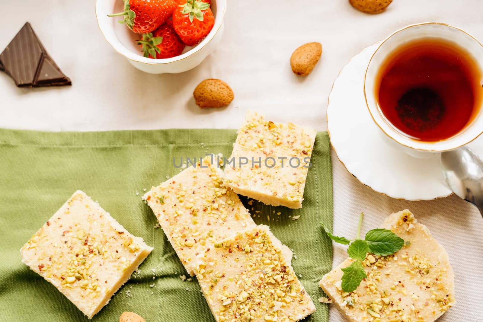 tea, milk, cakes, chocolate pieces, halva on the table