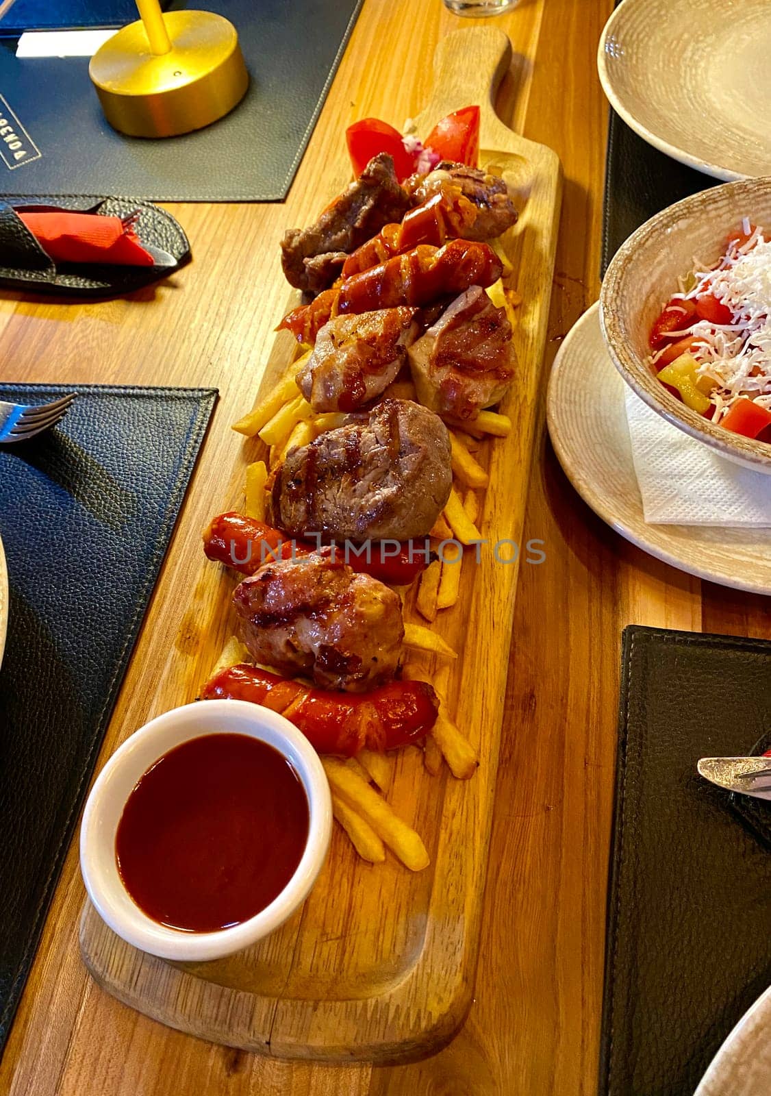 Excellent meats grilled and served with potatoes and vegetables. High quality vertical photo