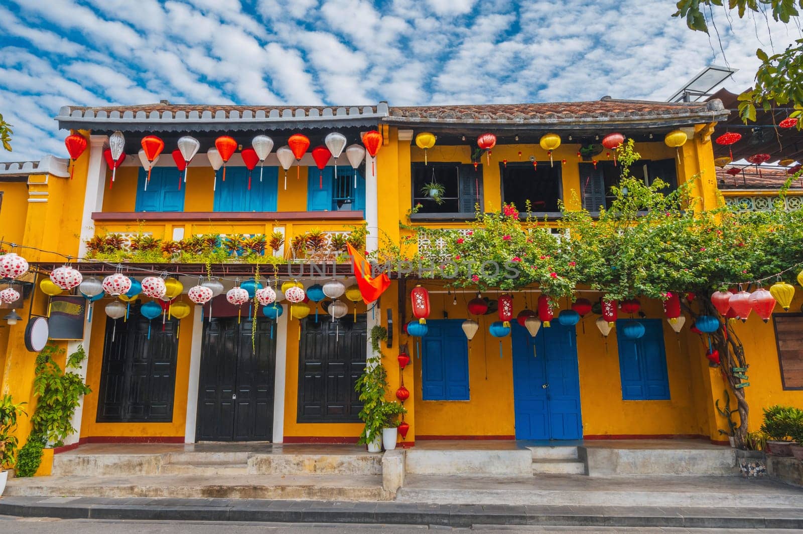 facade of an ancient Asian house decorated with colorful hanging Chinese lanterns for a holiday in the old town in Hoi An in Vietnam