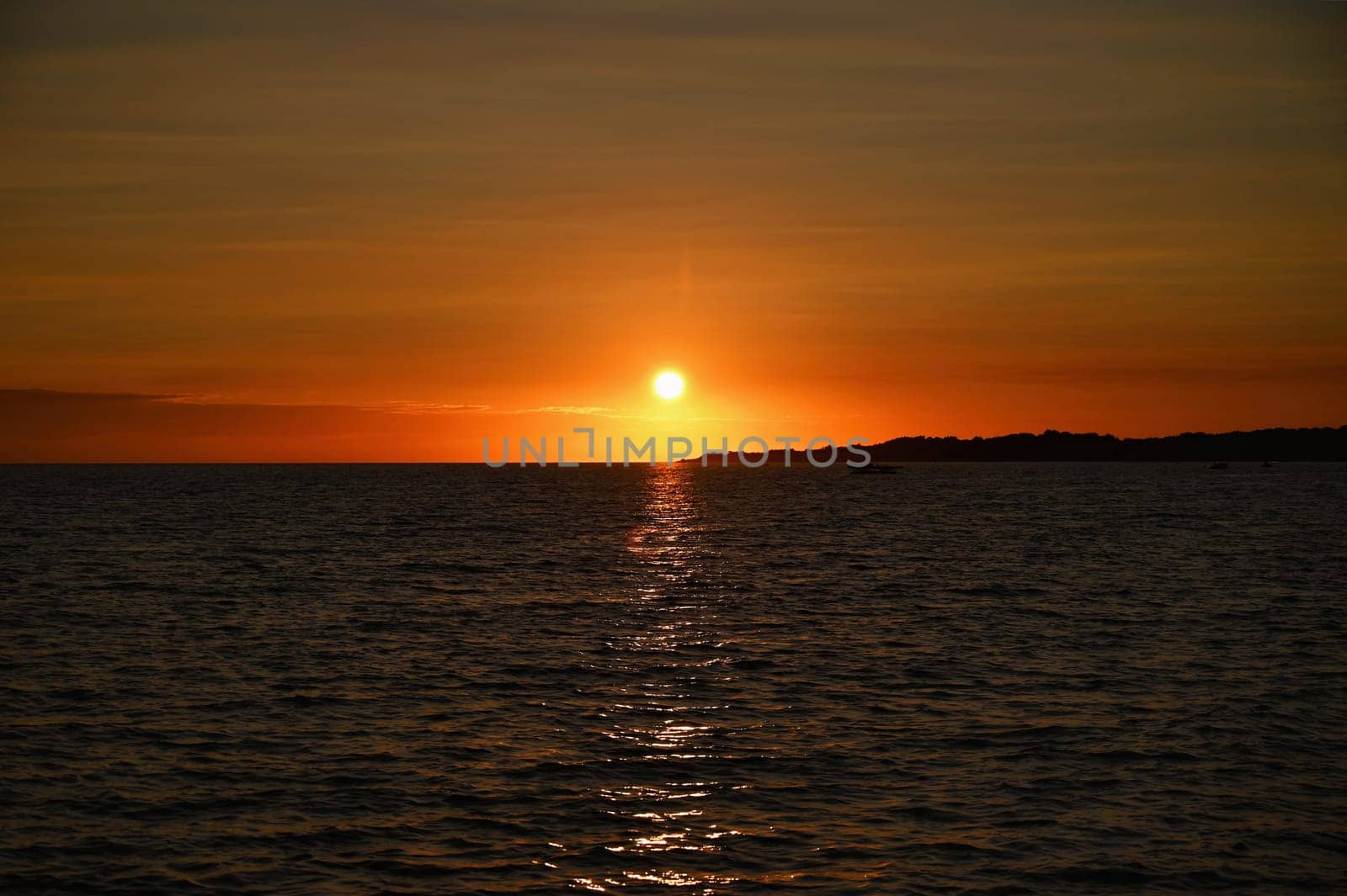 Beautiful colourful sunset on the beach with the sea and waves. A concept for travel, holidays and summer holidays by the sea. Greece - Corfu island - Agios Georgios