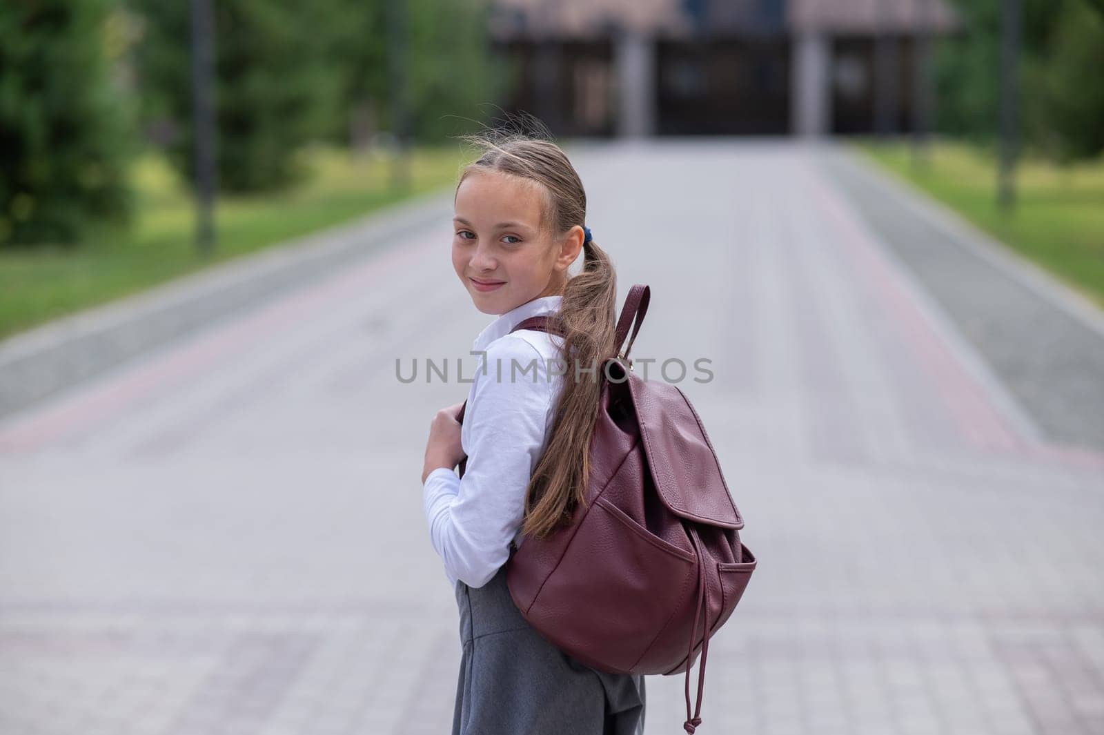 Portrait of caucasian schoolgirl in uniform and with backpack outdoors. by mrwed54