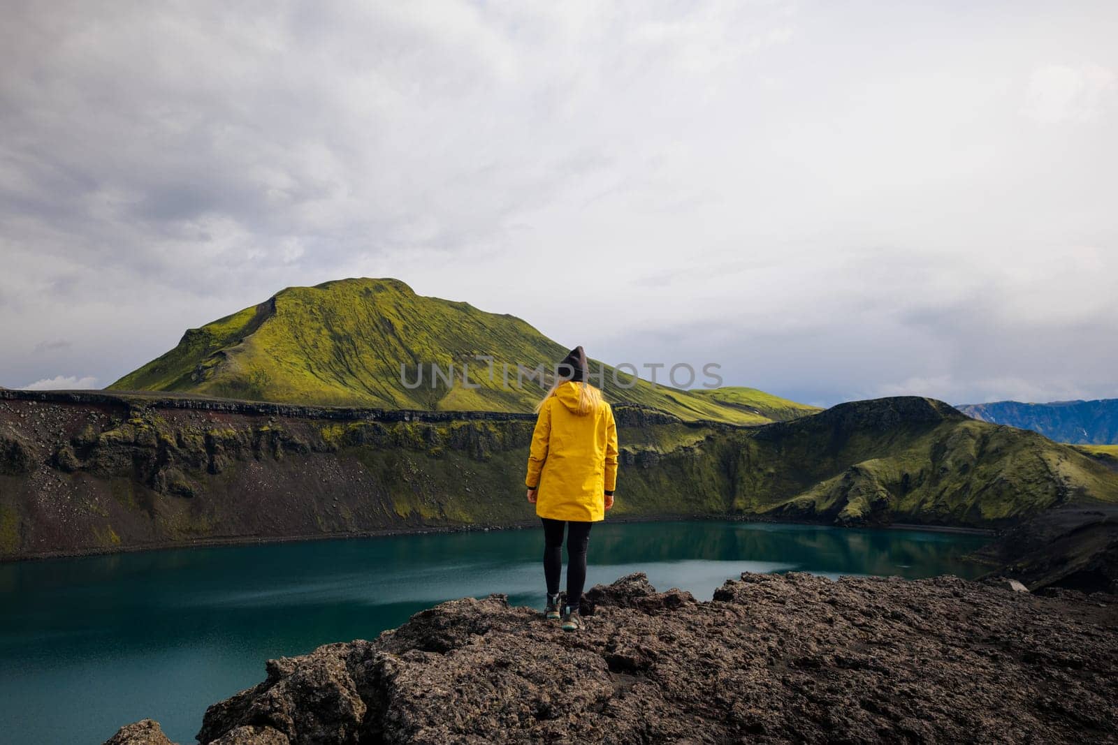 Backpacker girl contemplating the beauty of Blahylur lake in Iceland by Kustov