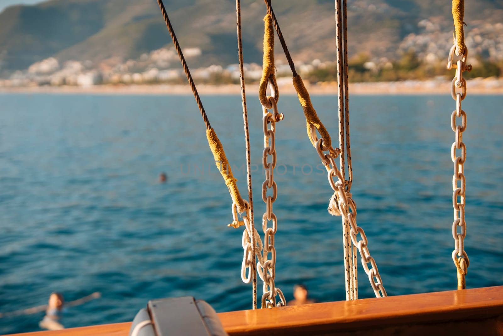 A picturesque and serene view of a sailboats ropes and chains beautifully set against a tranquil sea landscape