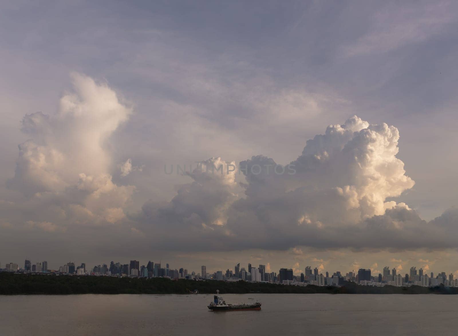 Bangkok, Thailand - 06 Aug 2024 - Beautiful Clouds in the Sky over Large Metropolitan City of Bangkok along Chao praya riverside with cargo ship. View of Skyscrapers and Dramatic Sky before Sunset, Space for text, Selective focus.