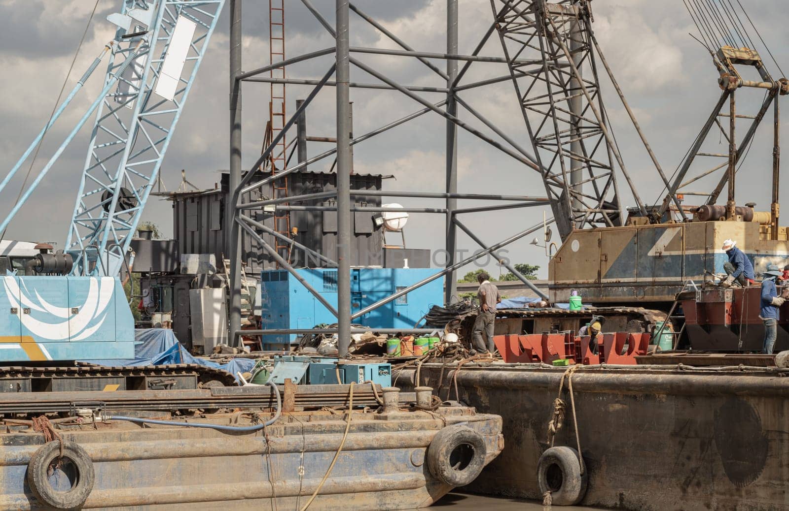 Bangkok, Thailand - 31 Aug, 2024 - Latticed boom crawler crane of heavy-duty used for rebuilding bridges near the river in Thailand. Jibs of mobile cranes and telescopic lifting cradles, Tower crane, Construction cranes, Construction and urban development, Space for text, Selective Focus.