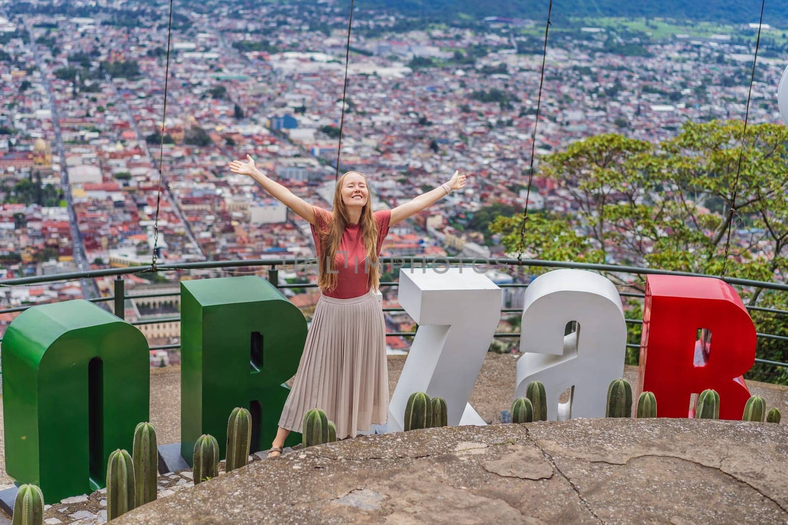 Female tourist in front of the panoramic view of Orizaba from Cerro del Borrego, Mexico. Travel, scenic landscape, and adventure concept.