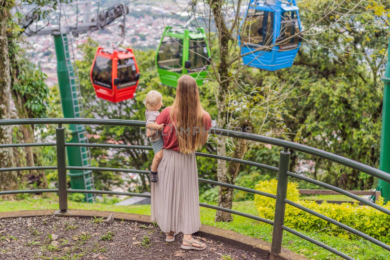Mom and her baby son tourists in front of the panoramic view of Orizaba from Cerro del Borrego, Mexico. Travel, scenic landscape, and adventure concept.