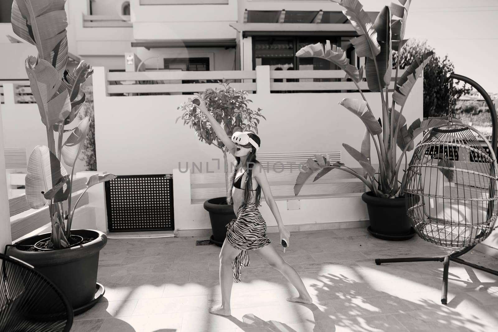 A vibrant dance performance, captured in black and white, takes place outdoors among lush greenery and nature