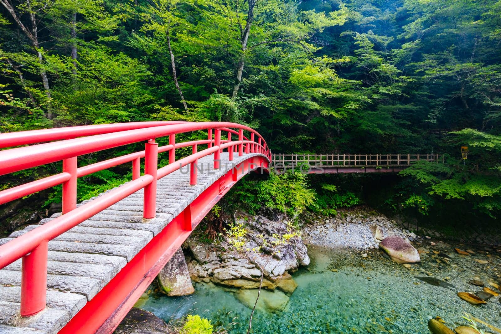 The magnificent Ryujin Falls and iconic red bridge at the start of autumn in Nakatsugawa City, near Sakashita in Japan