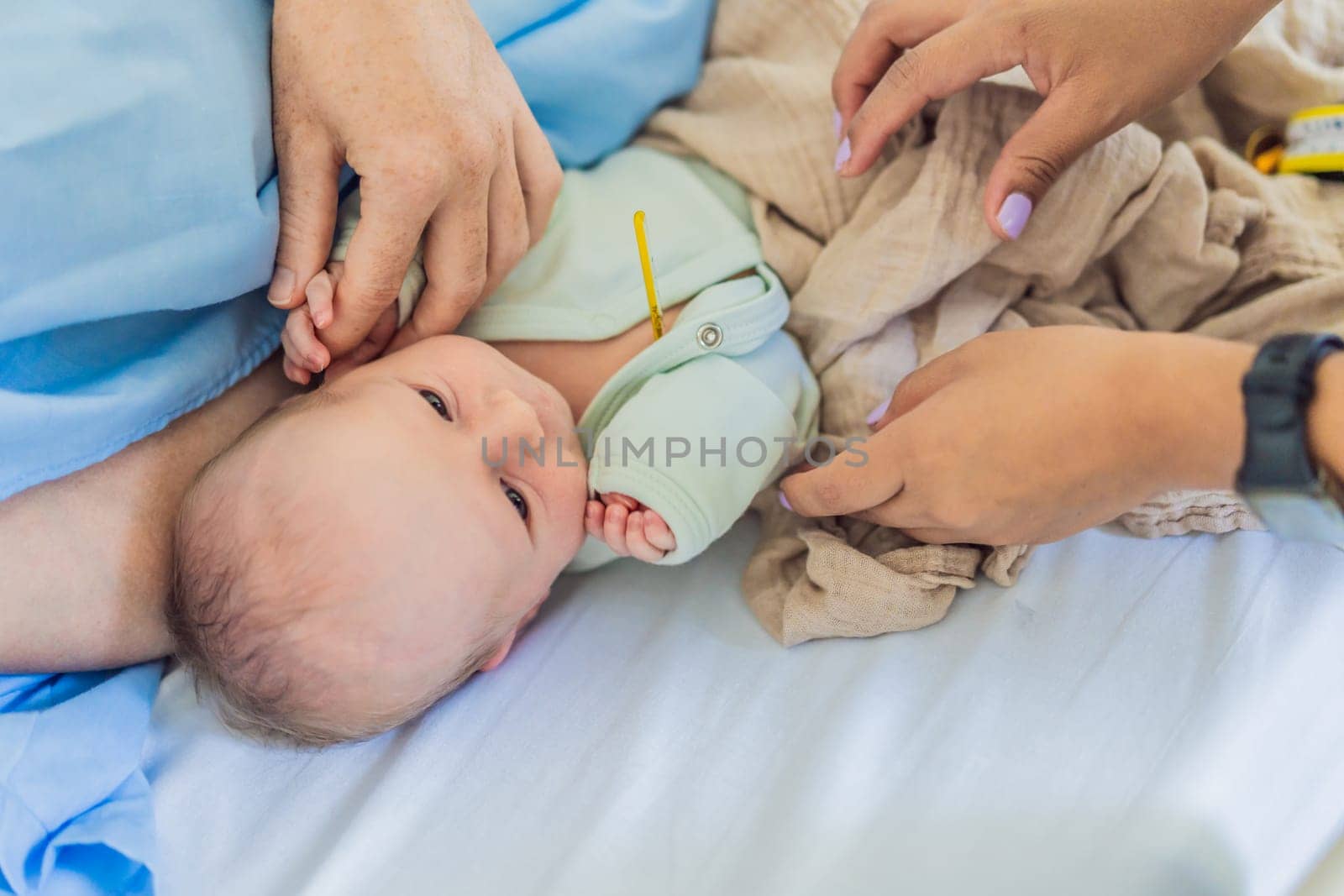 A nurse is taking a baby's temperature in the hospital. The gentle and careful procedure ensures the baby's comfort and well-being, allowing for accurate monitoring of their health.